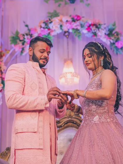 The moment of the ring exchange during an engagement ceremony, capturing the couple's focus and the significance of the event.