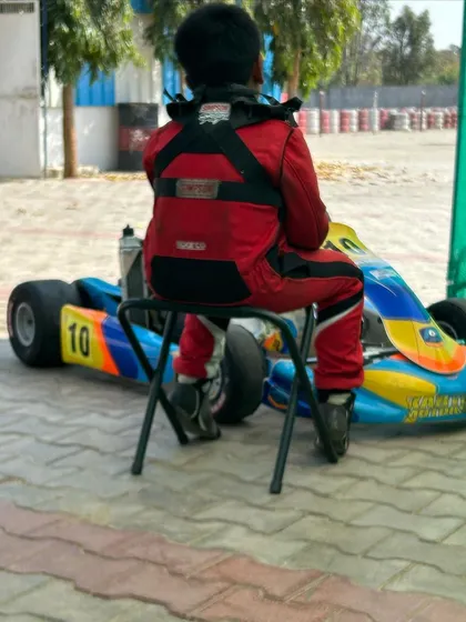 A young driver waits patiently for his turn on the track.