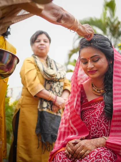 A serene moment as the bride receives blessings during her Haldi ceremony. The focus is on her peaceful expression and the significance of the ritual.