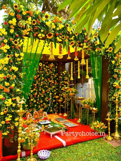 Another angle of the traditional floral mandap, highlighting the hanging temple bells and the vibrant colors of the sunflowers and green drapes.