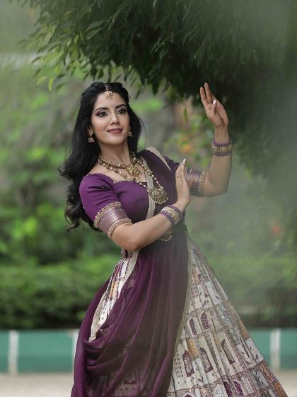 A posed shot that highlights the model's graceful posture and the elegant drape of her half saree.