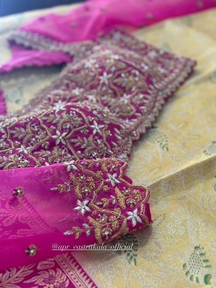 A vibrant pink blouse with all-over silver and gold floral embroidery.