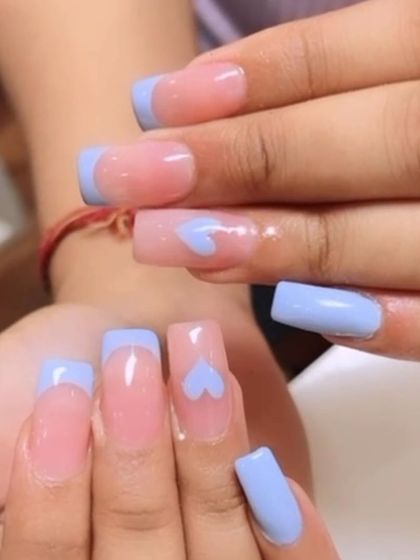 A sweet and simple design on square nails. This set features a light blue French tip, with one accent nail on each hand showing a sheer base with a single painted blue heart.