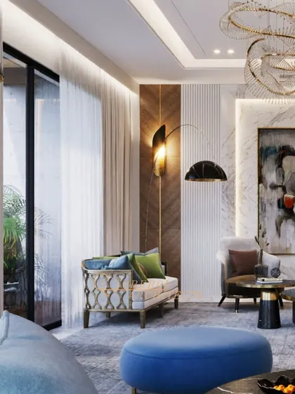 A living room designed with a vibrant color palette, featuring bold blue and green furniture against a backdrop of marble and wood. The sculptural chandelier adds an artistic touch.