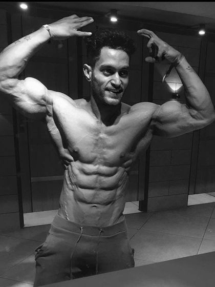 An artistic black and white shot hitting a classic pose. This highlights the muscularity and definition, proving that a great physique is a work of art.