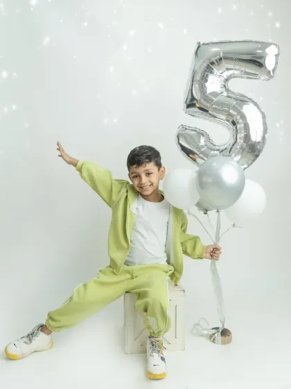 Fabulous five! This birthday boy is having so much fun posing with his balloons during his 5th birthday photoshoot.