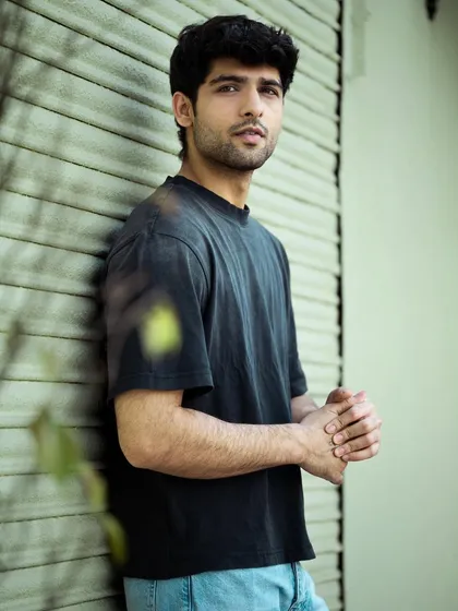 A medium shot showing more of the model's pose and outfit against the textured background. This type of image is useful for showcasing both the model and casual styling.