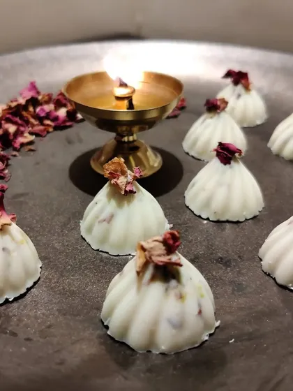 Here is a closer look at my Rasmalai-flavored white chocolate modaks, garnished with dried rose petals. These are one of my most popular fusion flavors, combining the taste of a classic Indian sweet with fine chocolate.