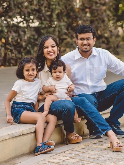 A casual family portrait taken outdoors on a stone ledge.