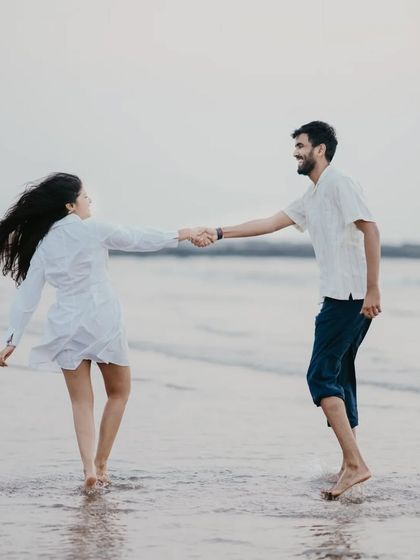 A playful moment of leading each other into the waves. This action shot captures the fun and carefree spirit of a pre-wedding beach session.