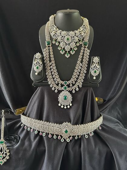 A closer look at the green and white stone bridal set. This rental includes a choker, a mid-length necklace, and a matching vaddanam, perfect for a coordinated look.