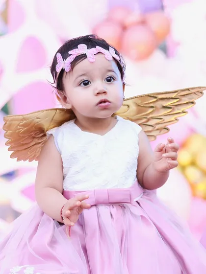 A little angel on her first birthday. We can create magical, themed shoots with adorable costumes like these golden wings to make the day extra special.