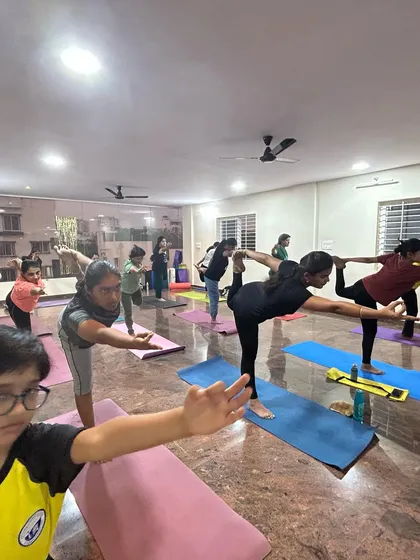A class works on balance and focus with Virabhadrasana III, or Warrior III Pose. This posture builds strength in the legs and core while improving concentration.