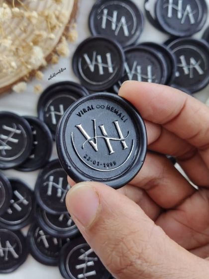 Custom wax seals created for a 25th-anniversary invitation. These seals feature the couple's initials and wedding date, adding a deeply personal and classic touch to their silver jubilee celebration.