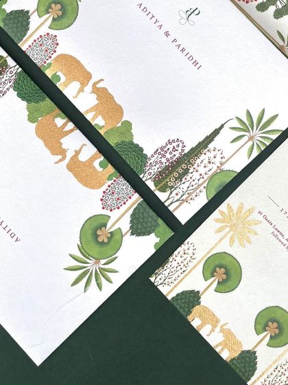 Minimalist invitations printed on beautiful, textured handmade paper. The design features a simple border of illustrated elephants and botanicals, with the texture of the paper adding to its organic feel.