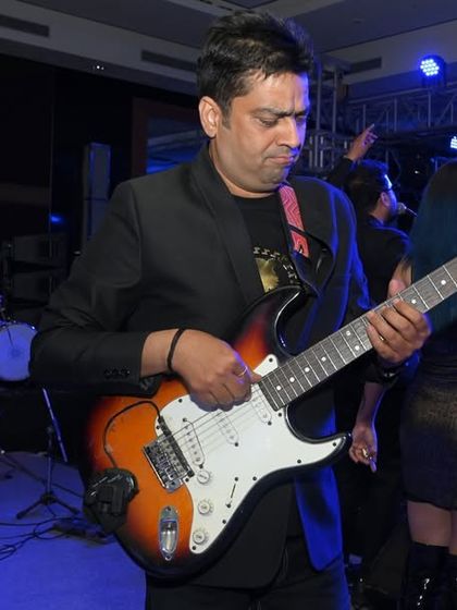 A guitarist lost in the music during a live band performance. I enjoy capturing these moments of intense focus and passion from musicians on stage.