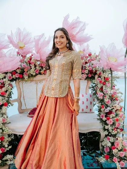 The beautiful bride-to-be, framed by the stunning floral arch and giant handmade lotuses of her mehendi decor.