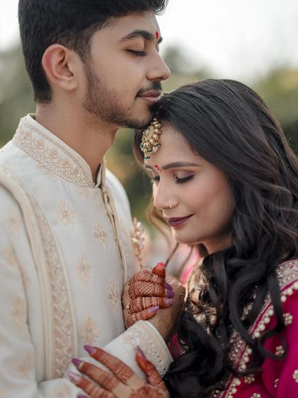 A tender forehead kiss, a quiet moment of love and reassurance shared between the couple on their wedding day.