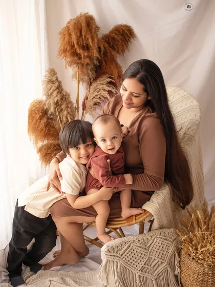 A mother's warm embrace for her two boys. This photo beautifully captures the love and connection in a cozy, boho-inspired setting.