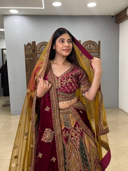 This pose showcases the full grandeur of the velvet lehenga, a perfect pre-loved option for a bride seeking a traditional yet unique look.