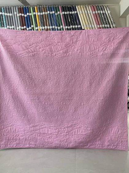 The solid pink backing of the scenic quilt.