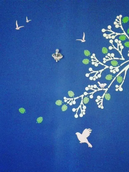 This nature-inspired wall art features birds in flight and a stylized tree, bringing a sense of peace and movement to the room.