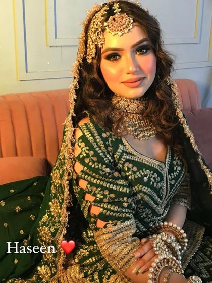 A stunning green Anarkali-style outfit with heavy gold embroidery. The unique sleeve design and the heavy jewellery make this a showstopper.