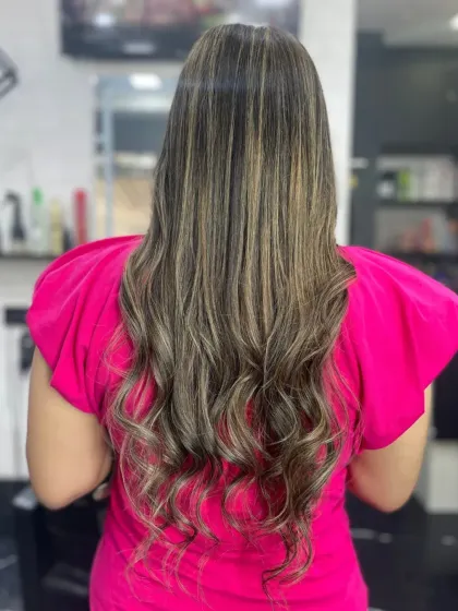 Long, healthy hair with soft balayage highlights, styled with gentle waves for a natural, sun-kissed effect.