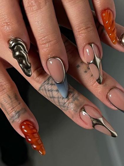 A futuristic design with 3D metallic elements, textured amber nails, and a mix of shapes and finishes.