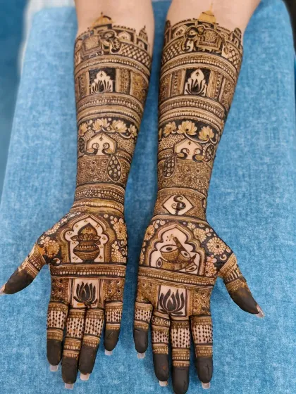 This design is rich with auspicious Hindu wedding symbols, including the sacred kalash, conch (shankh), and lotus flowers.