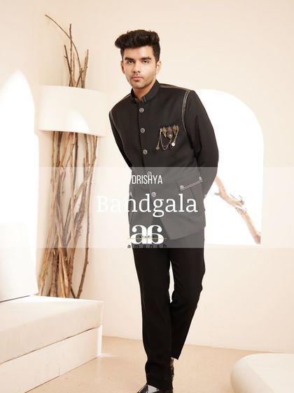 This full-length shot captures the complete black bandhgala ensemble. The tailored fit of the jacket and trousers creates a sleek, contemporary look suitable for high-end parties and evening receptions.