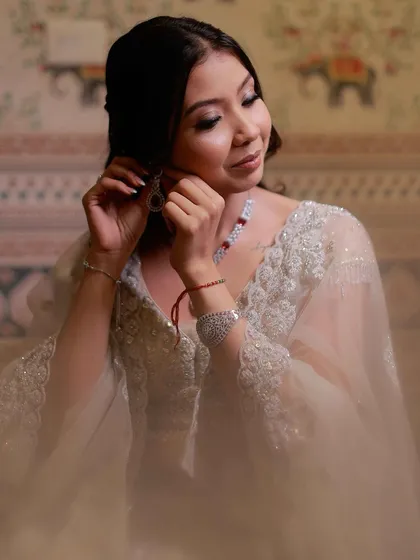 A beautiful moment of the bride getting ready. The soft, diffused lighting enhances the ethereal quality of her makeup.