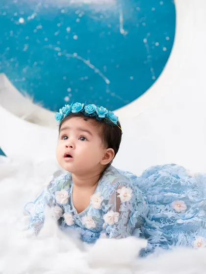A celestial dream. This baby girl in her beautiful blue dress looks like she's floating among the clouds and stars.