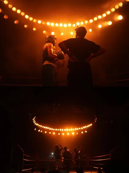 A dramatic moment on the Star Cement set. The warm, low-key lighting with a single overhead source creates a feeling of intimacy and focus.