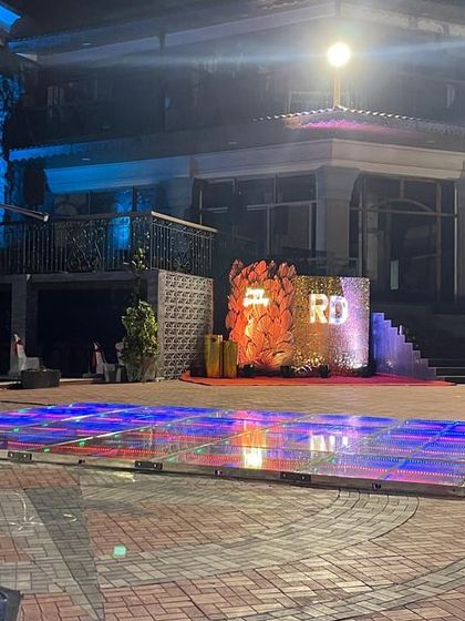 This wide shot shows how a well-designed backdrop can command a large outdoor space. The setup includes an LED dance floor, making it the center of the party.
