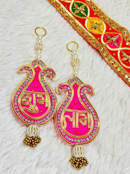 This paisley-shaped Shubh Labh latkan in bright pink and gold is a stylish way to decorate your home. The simple yet elegant design is perfect for modern tastes.