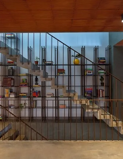 This staircase is a central feature in our 'Brickly Affair' project. We designed the mild steel railing to double as a multi-level bookshelf, transforming a simple circulation space into a functional and interactive family library.