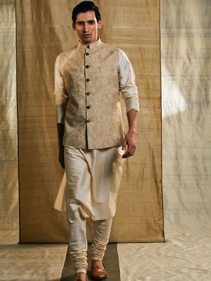 A classic touch for your traditional events. This beige kurta pajama in raw silk features a Nehru jacket embellished with Tussar silk thread work.