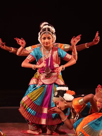 A beautiful moment from our 'Sadhana Classical Dance Festival', where a senior dancer portrays a multi-armed deity, supported by younger students in a gesture of reverence.