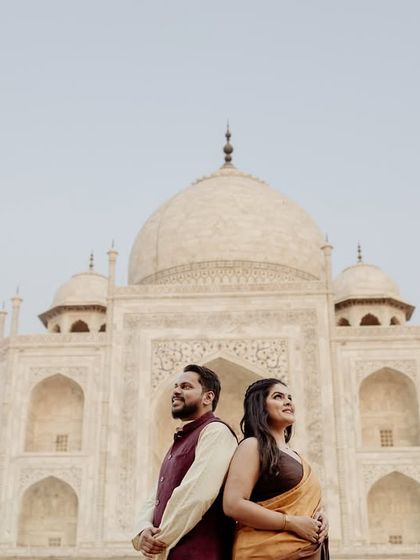 A classic back-to-back pose, highlighting the couple's traditional attire against the white marble of the Taj. This composition is elegant and timeless.