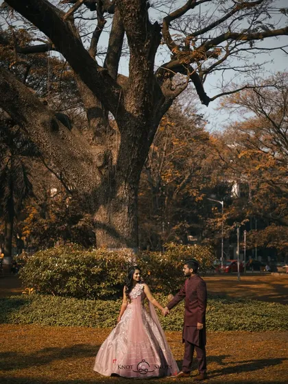 A wide shot showing the couple against a beautiful, large tree. This emphasizes the setting and creates a sense of grandeur for their portrait.
