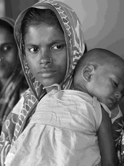 A moving black and white photograph by Sudharak Olwe from the "Endangered Species" exhibition. This image of a mother with her child captures the human element at the heart of the social issues we aim to highlight through art.