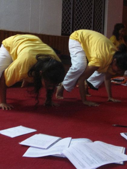 Two students practicing Kakasana (Crow Pose) side-by-side during a TTC session from 2011. The focus and determination are timeless.