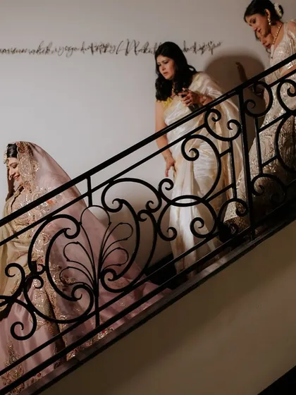 An artistic shot of the bride and her squad walking down a staircase, the iron railing creating a beautiful graphic frame.