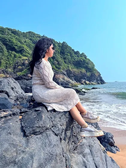 A trekker sitting on the rocks, enjoying the ocean view on our Gokarna beach trek.