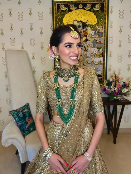 A happy bride showing off her complete look, with her hair styled in a sophisticated updo perfect for her big day.