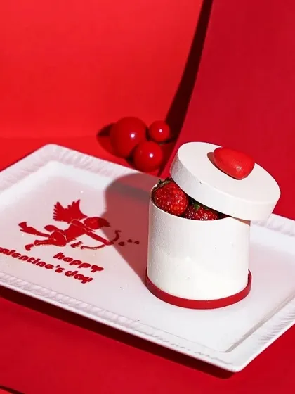 A creative Valentine's dessert shaped like a gift box, with a "Happy Valentine's Day" message on the plate. This conceptual shot is perfect for a special, limited-edition menu item.