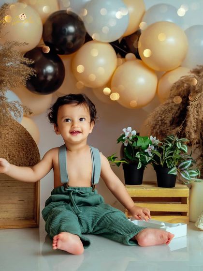 A happy smile from our boho-themed session. The combination of natural textures and warm balloons creates a timeless look for a first birthday photoshoot.
