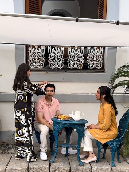 A behind-the-scenes look at a cafe scene from the Pondicherry shoot. The stylist is making a final adjustment before the camera rolls.