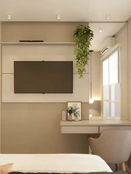 A compact and functional bedroom space with an integrated TV unit and study desk. The hanging plant adds a touch of greenery.